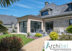 Extension en briques enduites avec une toiture trois pentes